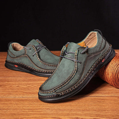 Men's stylish green leather loafers with braided detail on a wooden surface, featuring slip-on design and comfort for formal and casual occasions.