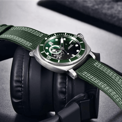 Valenor Automatic Diver Signature watch with green dial and nylon strap, displayed on black headphones, luxury timepiece.