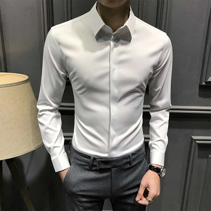 Elegant men's wrinkle-free shirt in white, button-down style for a sophisticated look, paired with dark trousers.